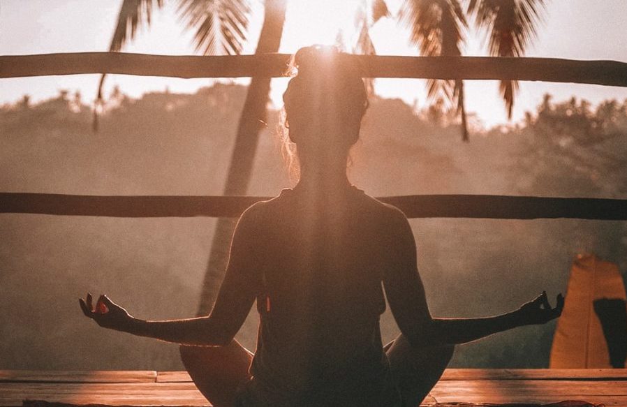 woman doing yoga meditation on brown parquet flooring